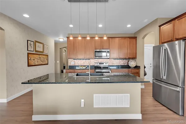 a kitchen with kitchen island a counter top space cabinets and stainless steel appliances