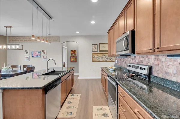 a kitchen with stainless steel appliances granite countertop a sink stove and cabinets