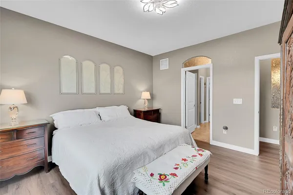 a bedroom with a bed and wooden floor