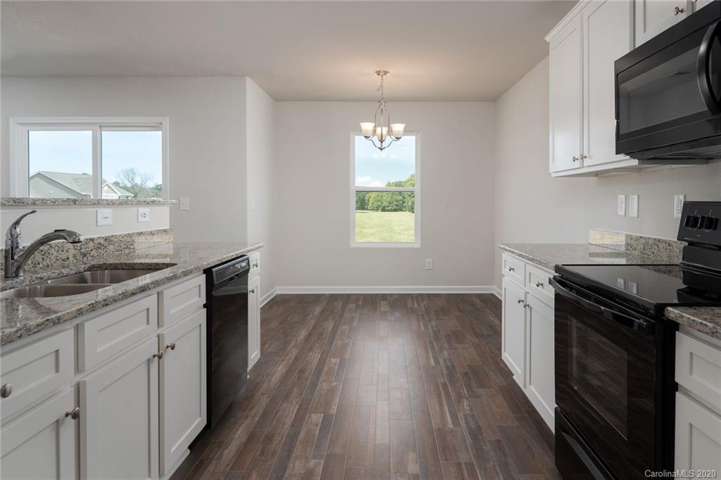 1215 Culver Spring Way Charlotte, NC 28215 - Photo 11 of 13 a kitchen with granite countertop a stove top oven a sink dishwasher and wooden cabinets with wooden floor