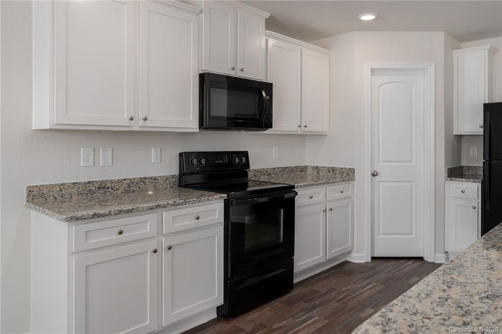1215 Culver Spring Way Charlotte, NC 28215 - Photo 9 of 13 a kitchen with stainless steel appliances granite countertop a stove a microwave and a white cabinets