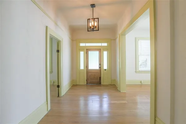 a view of a hallway with wooden floor and windows
