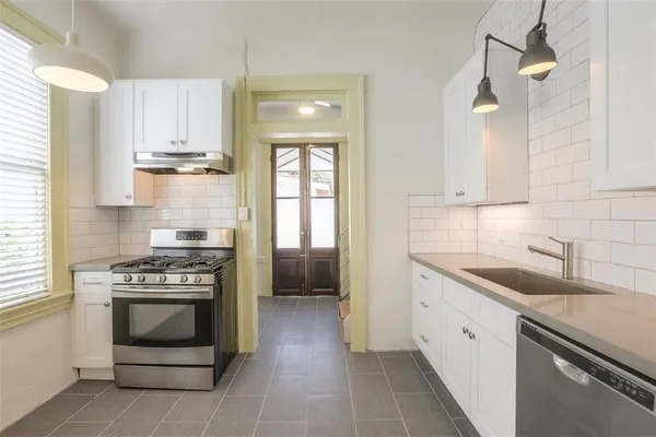 a kitchen with a stove sink and cabinets