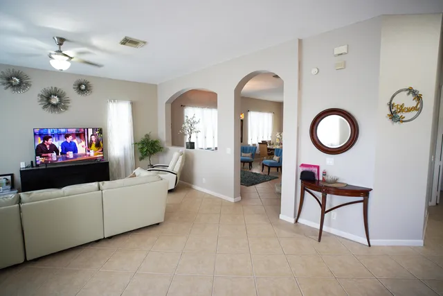 a living room with furniture a chandelier and a mirror