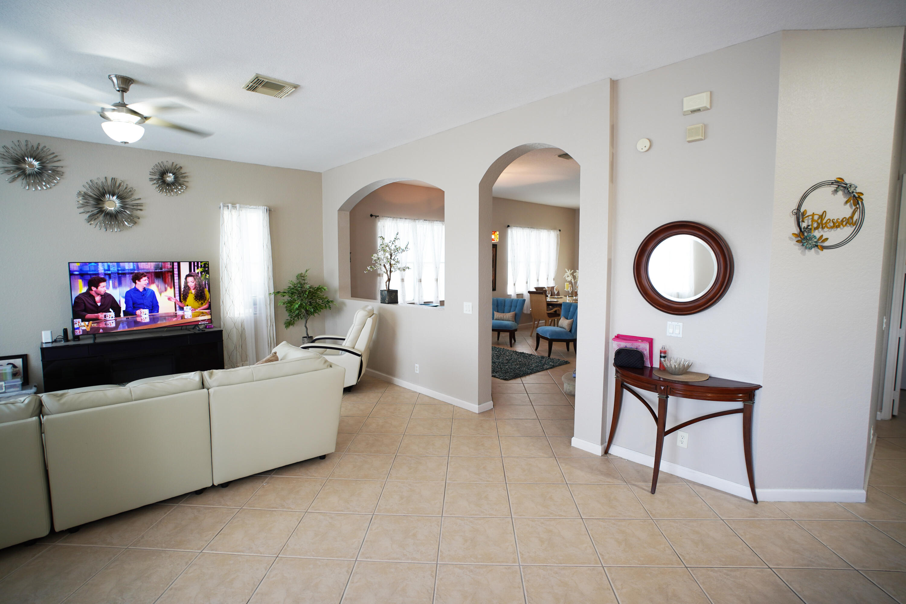 673 Gazetta Way West Palm Beach, FL 33413 - Photo 12 of 35 a living room with furniture a chandelier and a mirror