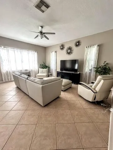 a living room with couches a flat screen tv and a stove