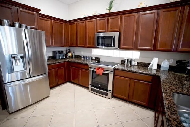 a kitchen with stainless steel appliances granite countertop a refrigerator stove top oven and sink