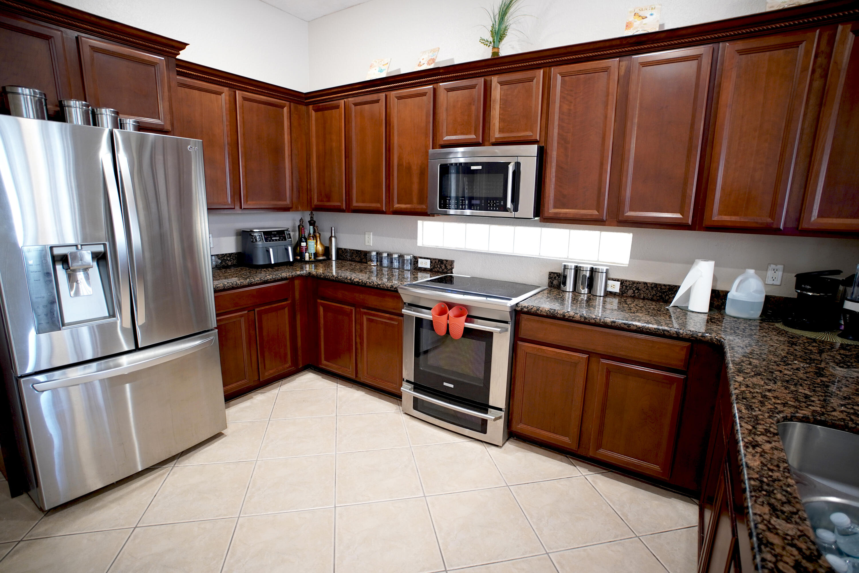 673 Gazetta Way West Palm Beach, FL 33413 - Photo 14 of 35 a kitchen with stainless steel appliances granite countertop a refrigerator stove top oven and sink