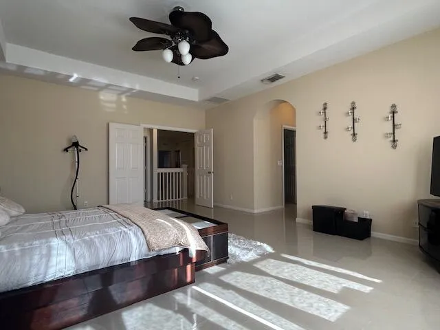 a bedroom with a bed and a ceiling fan