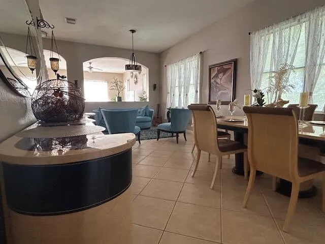 a living room with furniture a large window and a chandelier
