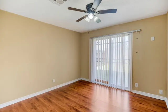 a view of a white house with a big yard and large tree