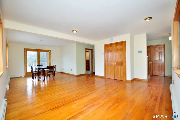 a view of empty room with window and wooden floor