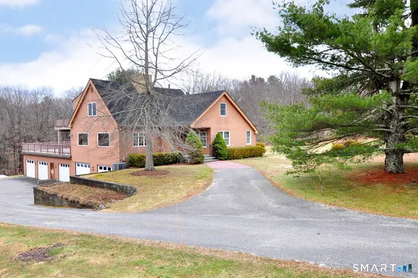 a front view of house with yard and trees in the background