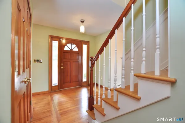 a view of an entryway with wooden floor and door