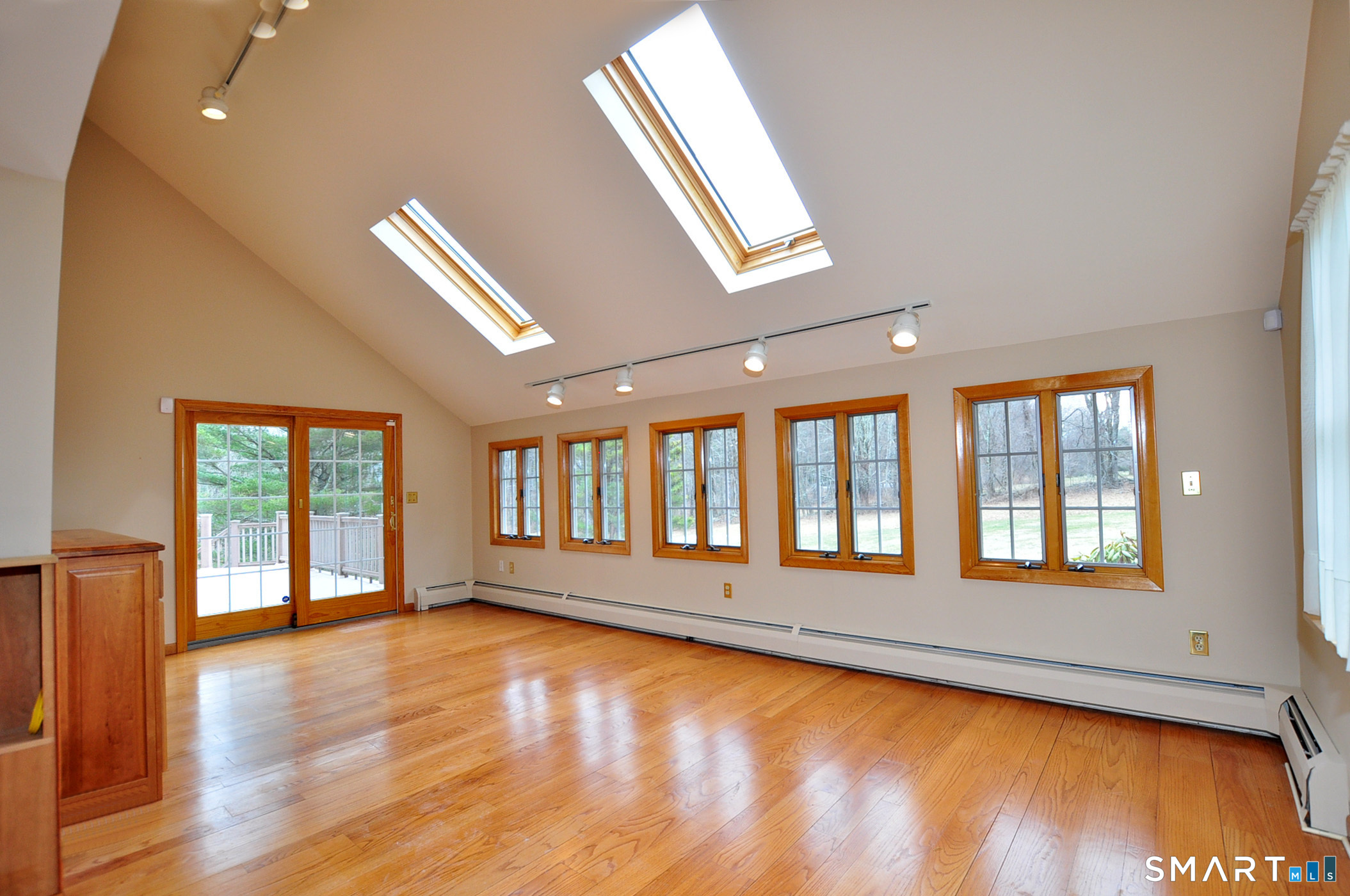 243 Milton Road Goshen, CT 06756 - Photo 7 of 38 Family Room features a vaulted ceiling, skylights, loads of windows and sliders to a wrap-around rear deck.