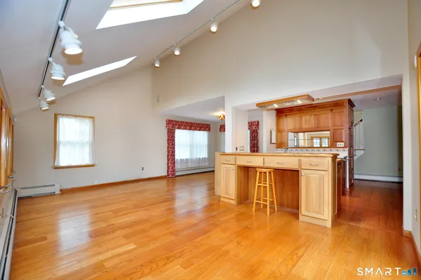 a view of empty room with kitchen and window