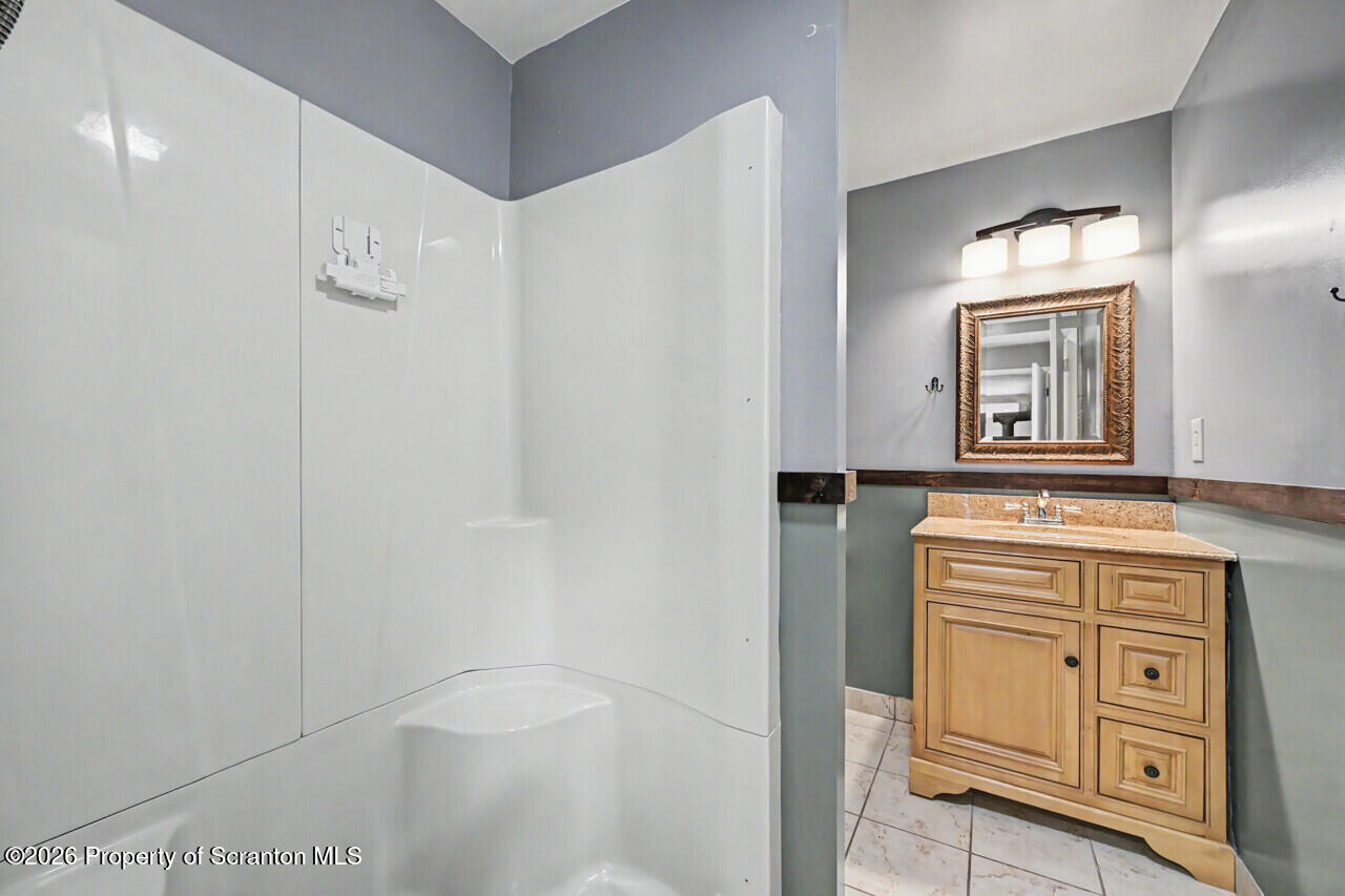 211 Buckingham Street Moscow, PA 18444 - Photo 57 of 83 a bathroom with a granite countertop sink a toilet and a mirror