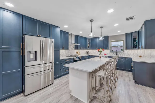 a kitchen with kitchen island a sink stove and refrigerator