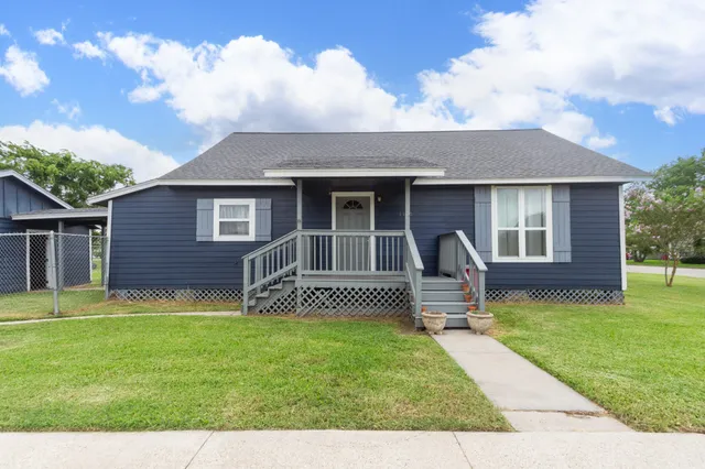 a front view of house with a garden