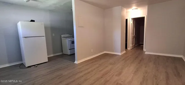 a view of a room with wooden floor and a hallway