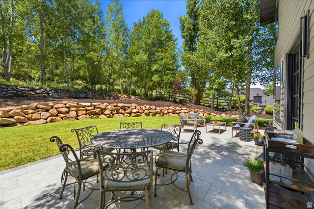 3027 Homestead Road Park City, UT 84098 - Photo 62 of 62 Expansive stone paver patio featuring multiple seating areas, a manicured lawn, and a natural stone retaining wall