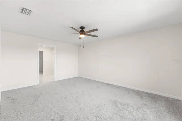 an empty room with a ceiling fan and a window