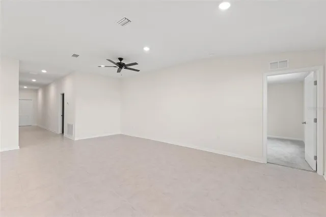 an empty room with a ceiling fan and a window