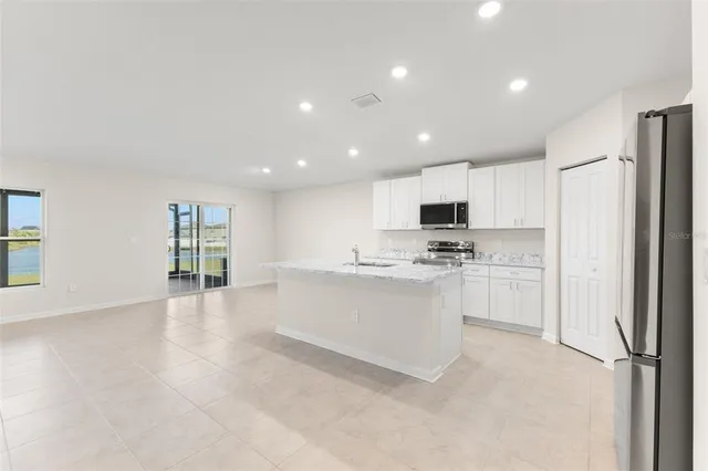 a kitchen with white cabinets and refrigerator