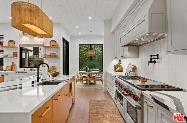 a kitchen with stove and a dining table