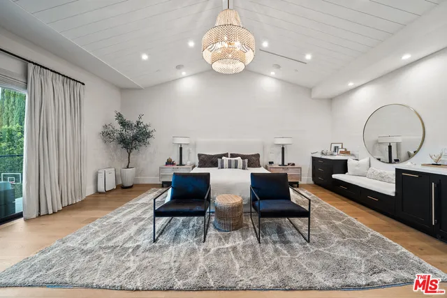 a living room with furniture a chandelier and a rug
