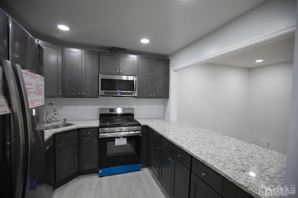 4208 Hana Road Edison, NJ 08817 - Photo 20 of 34 a kitchen with granite countertop stainless steel appliances and sink