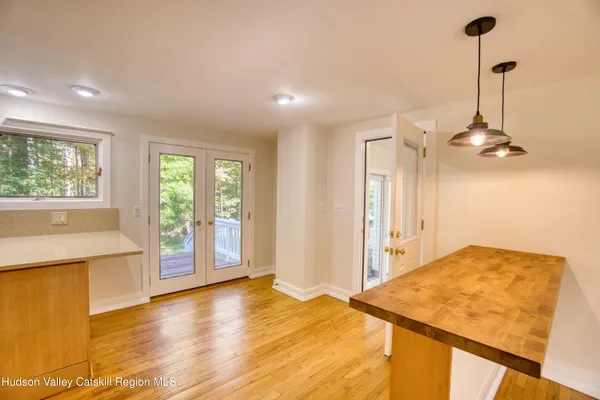 a view of a kitchen with kitchen island wooden floors and a sink