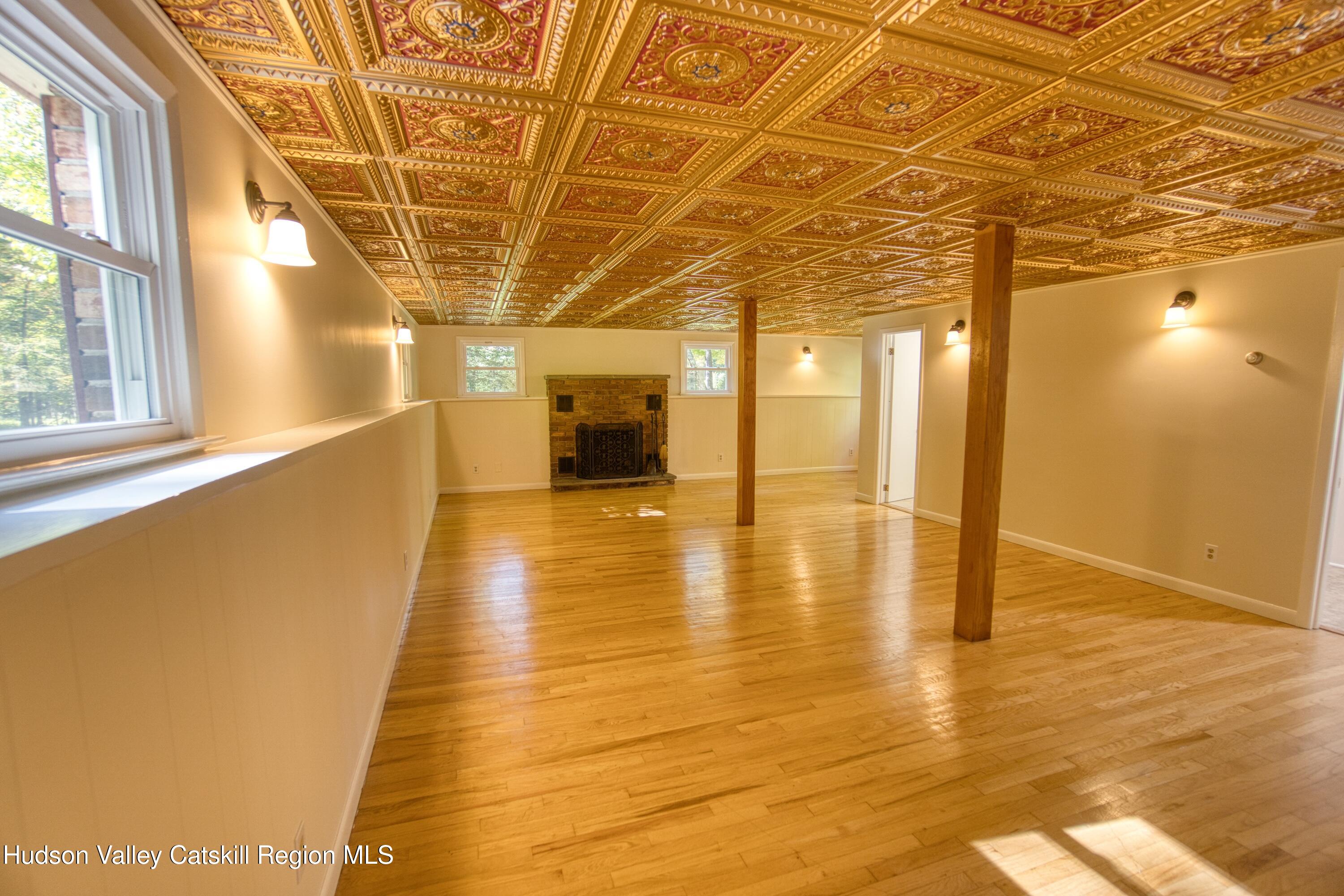 177 Buck Road Stone Ridge, NY 12484 - Photo 19 of 37 a view of an empty room with wooden floor and a bathroom