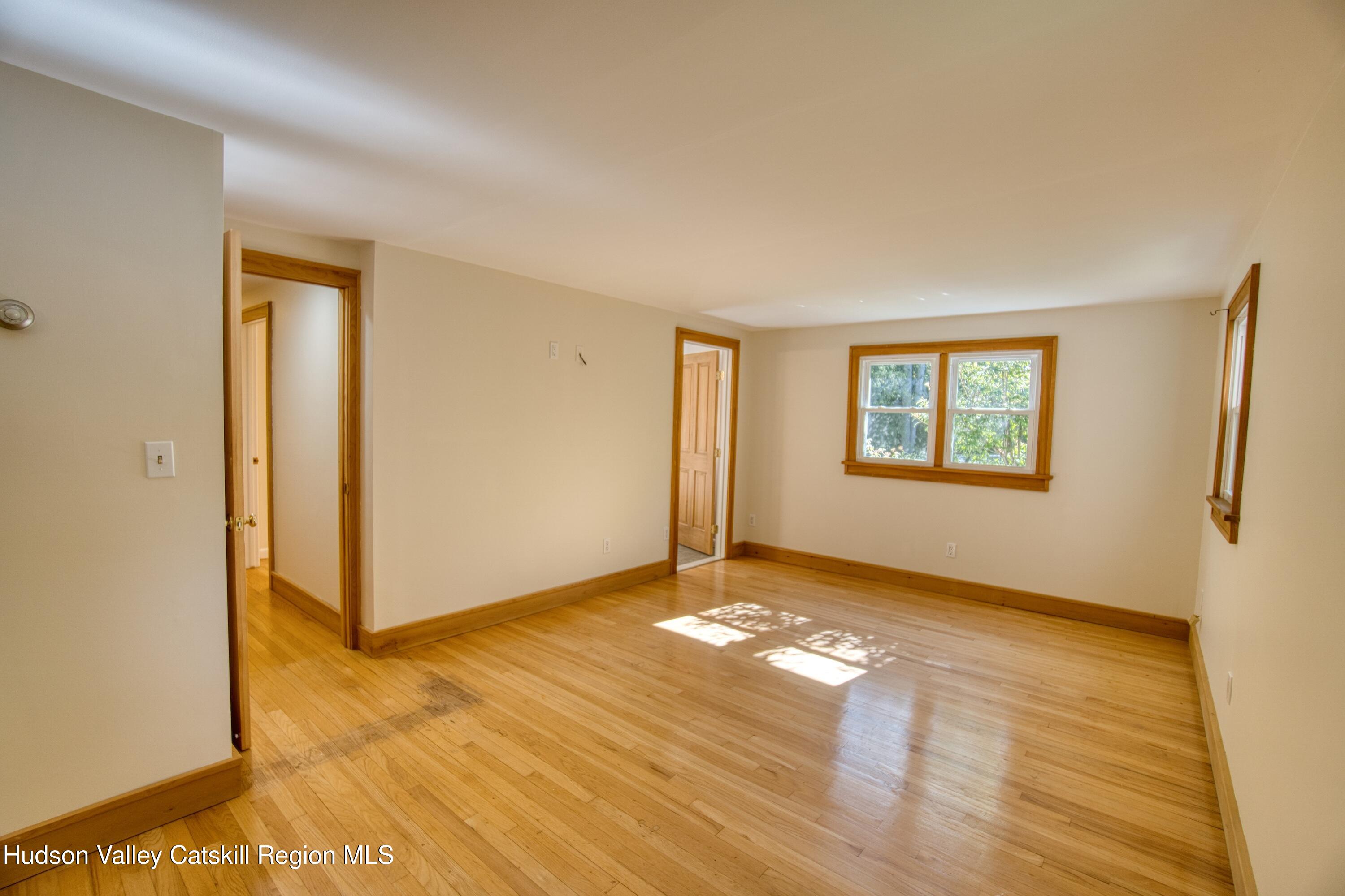 177 Buck Road Stone Ridge, NY 12484 - Photo 26 of 37 a view of an empty room with window and wooden floor