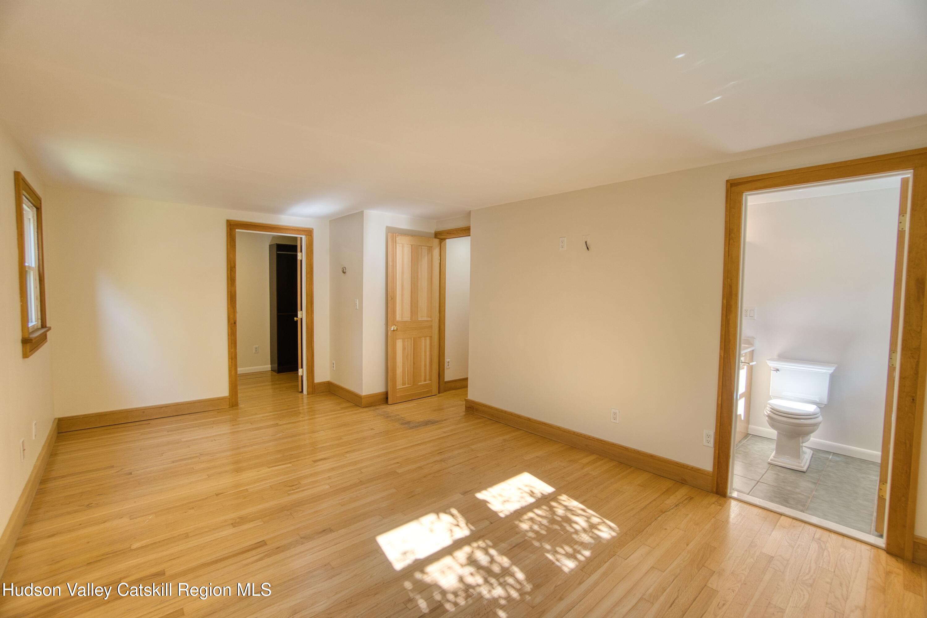 177 Buck Road Stone Ridge, NY 12484 - Photo 27 of 37 a view of an empty room with wooden floor and a window