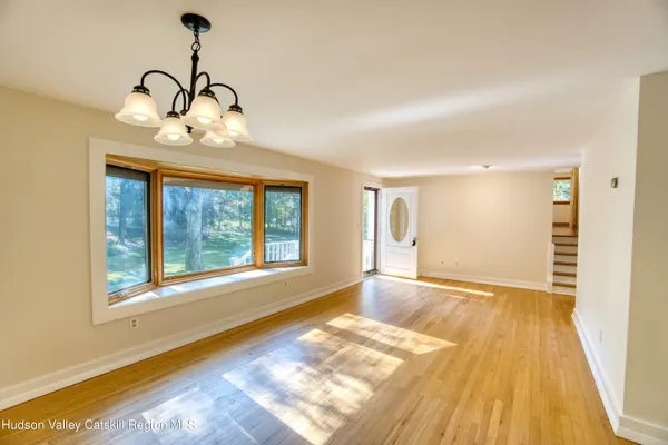 a view of empty room with wooden floor and window
