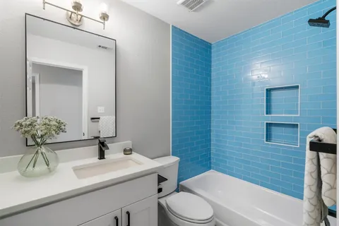 a bathroom with a sink a toilet and mirror