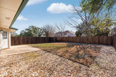 a view of a backyard with wooden fence