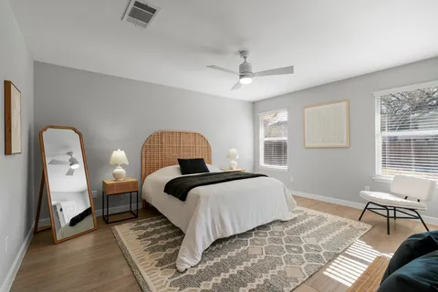 a bedroom with a bed wooden floor and a window