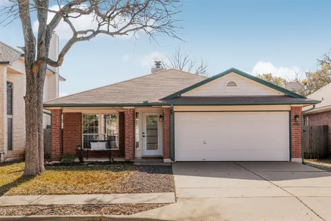 a view of a white house with a large tree and a yard