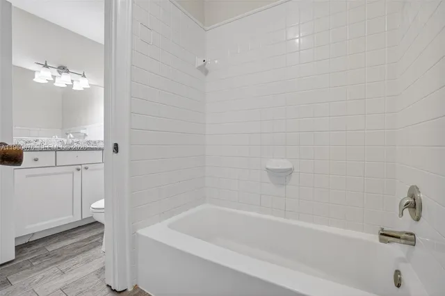 a bath tub sitting next to a white sink and vanity