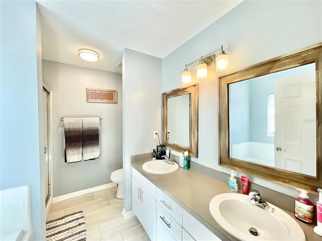 a bathroom with a double vanity sink mirror and
