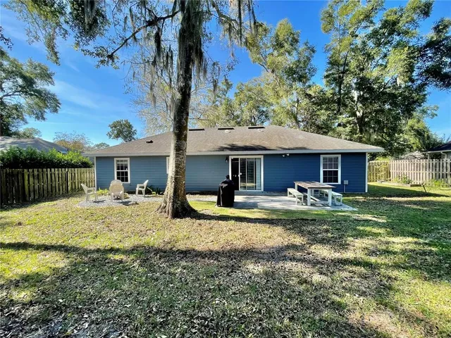 a view of a house with backyard and trees