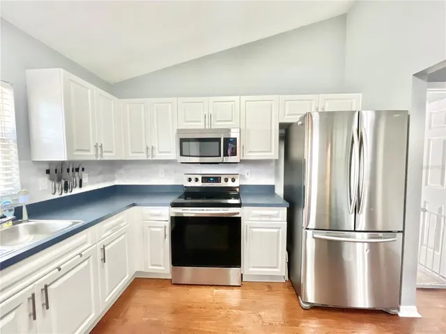 a kitchen with stainless steel appliances granite countertop a sink stove and cabinets