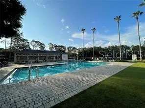 a view of a swimming pool with a patio and a yard