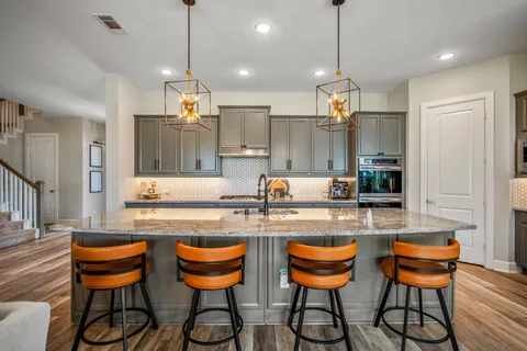 a kitchen with granite countertop a dining table chairs and white cabinets