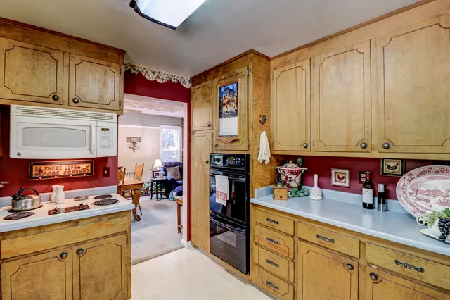 a kitchen filled with a stove and white cabinets