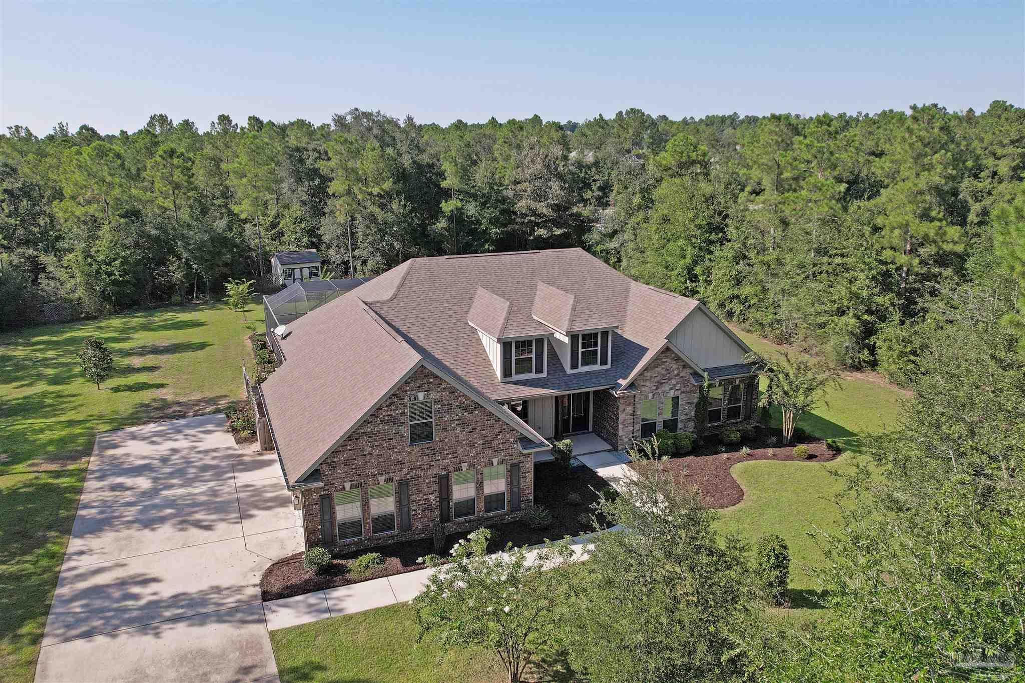 a aerial view of a house next to a big yard
