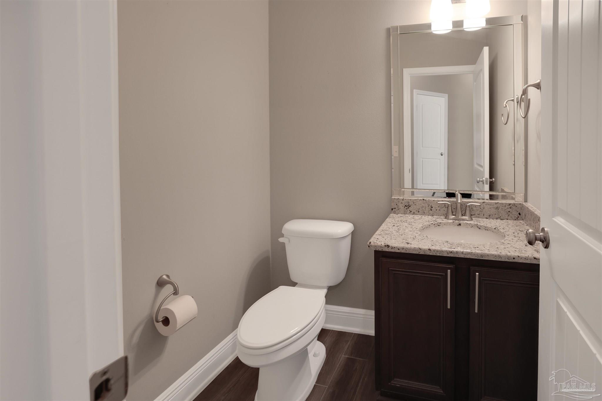 5847 Mossy Creek Lane Pace, FL 32571 - Photo 29 of 50 a bathroom with a granite countertop sink toilet and mirror