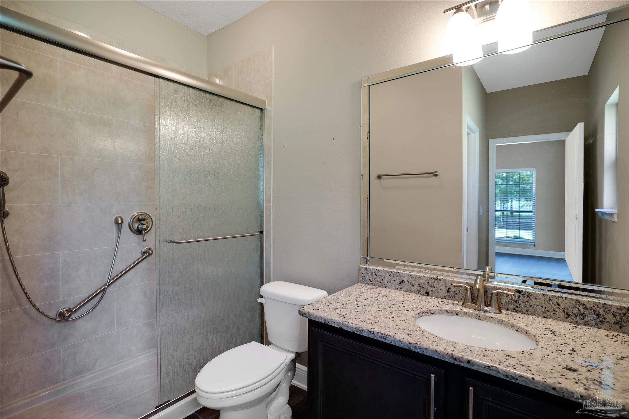 5847 Mossy Creek Lane Pace, FL 32571 - Photo 34 of 50 a bathroom with a granite countertop sink toilet and shower